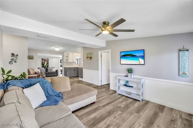 living room featuring ceiling fan and light hardwood / wood-style flooring