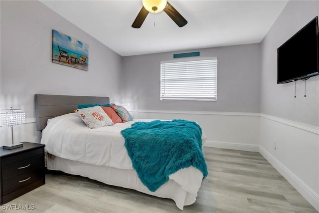 bedroom featuring ceiling fan, light wood finished floors, and baseboards