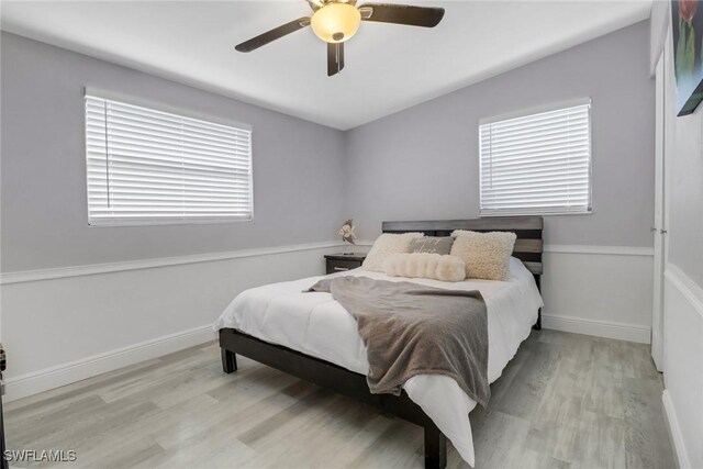 bedroom with ceiling fan, light wood-type flooring, and lofted ceiling