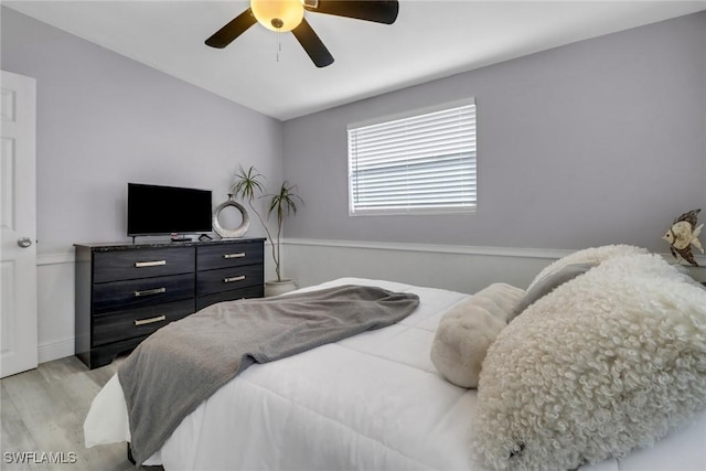 bedroom with a ceiling fan, light wood-type flooring, and lofted ceiling