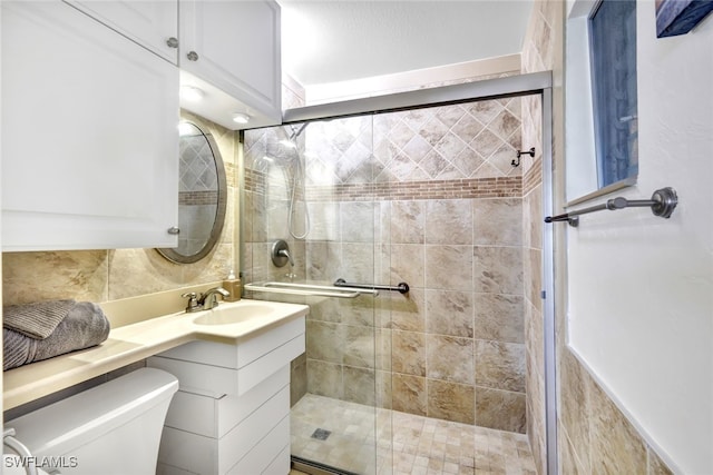 bathroom with backsplash, a shower stall, toilet, and vanity