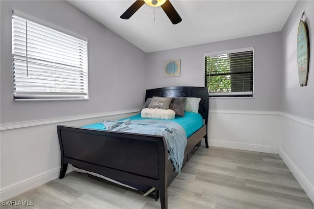 bedroom with ceiling fan, baseboards, and wood finished floors