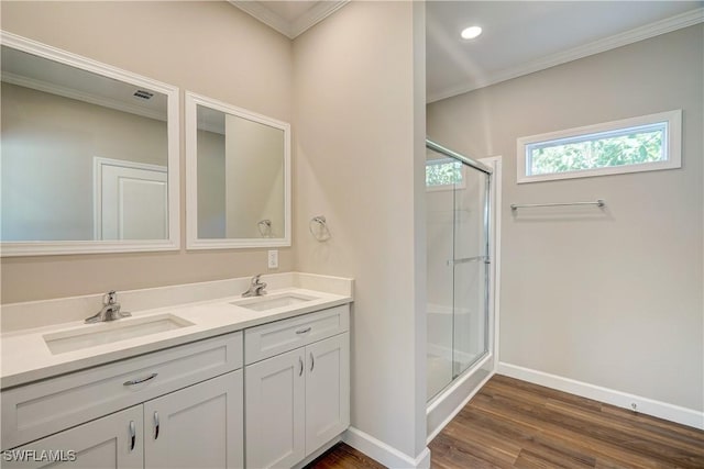 bathroom featuring crown molding, vanity, a shower with shower door, and hardwood / wood-style flooring