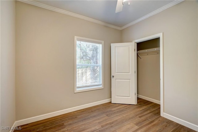 unfurnished bedroom featuring ceiling fan, light wood-type flooring, crown molding, and a closet