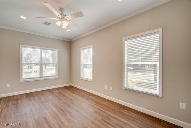 empty room featuring ceiling fan, light hardwood / wood-style floors, crown molding, and a wealth of natural light