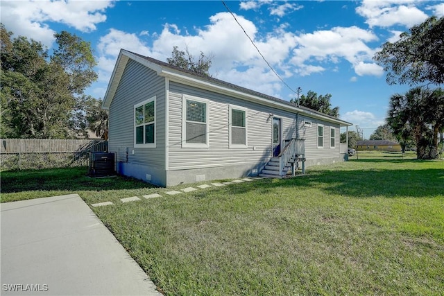 view of front of home with central AC and a front lawn