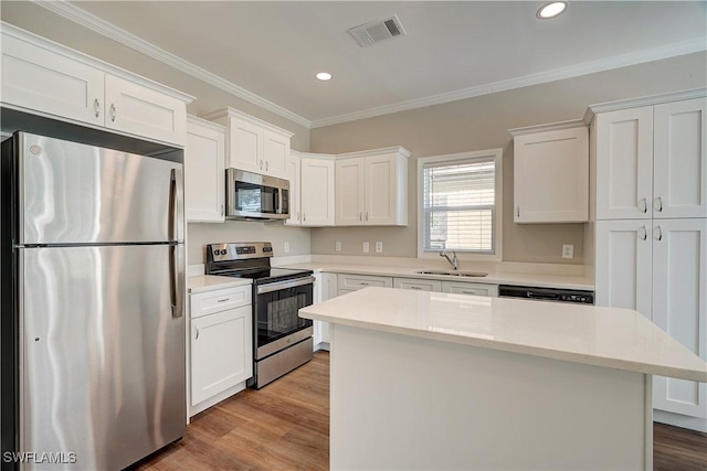 kitchen with a center island, white cabinets, sink, light hardwood / wood-style flooring, and stainless steel appliances