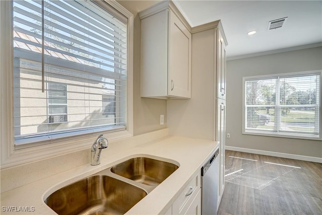 kitchen with dishwasher, light wood-type flooring, crown molding, and sink