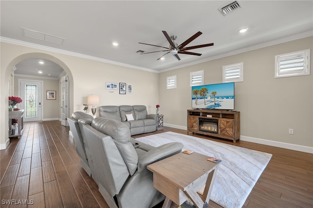 living room featuring ornamental molding, ceiling fan, and dark wood-type flooring