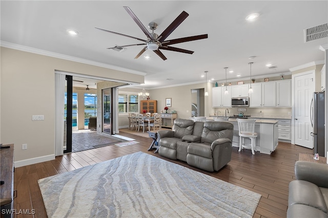 living room featuring dark hardwood / wood-style floors, ceiling fan, and crown molding