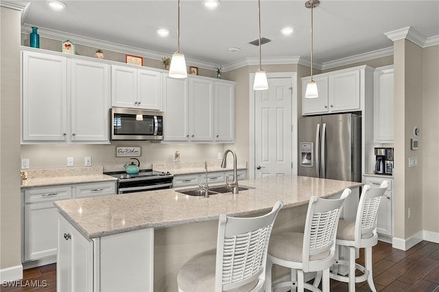 kitchen with white cabinets, sink, an island with sink, dark hardwood / wood-style flooring, and stainless steel appliances