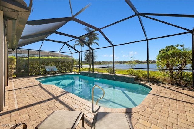 view of swimming pool featuring glass enclosure, a patio area, and a water view