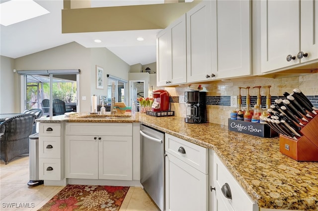 kitchen with kitchen peninsula, sink, stainless steel dishwasher, light tile patterned floors, and white cabinetry