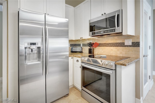 kitchen with light stone countertops, white cabinets, stainless steel appliances, and light tile patterned floors