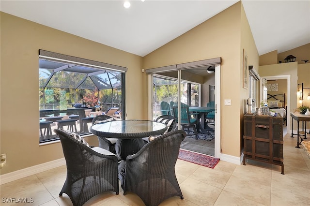 tiled dining space featuring vaulted ceiling