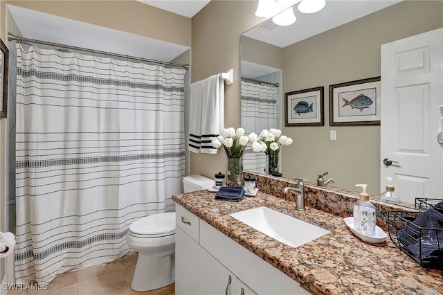 bathroom with tile patterned flooring, vanity, and toilet