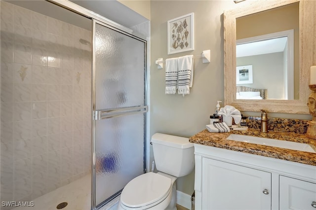 bathroom featuring vanity, toilet, and an enclosed shower