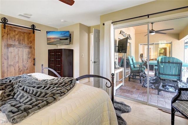 bedroom with light tile patterned floors, a barn door, and ceiling fan