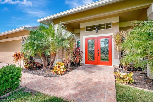 entrance to property featuring a garage and french doors