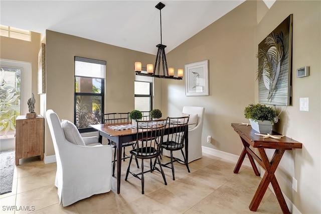 tiled dining space featuring plenty of natural light, a chandelier, and vaulted ceiling