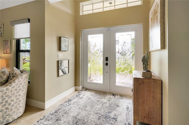 entryway with french doors, a wealth of natural light, and light tile patterned flooring