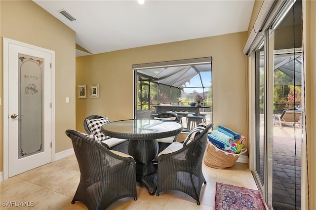 dining space with light tile patterned floors and vaulted ceiling