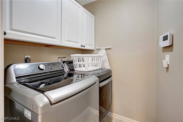 washroom with separate washer and dryer and cabinets