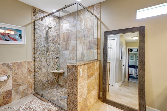 bathroom featuring a shower with door and ceiling fan