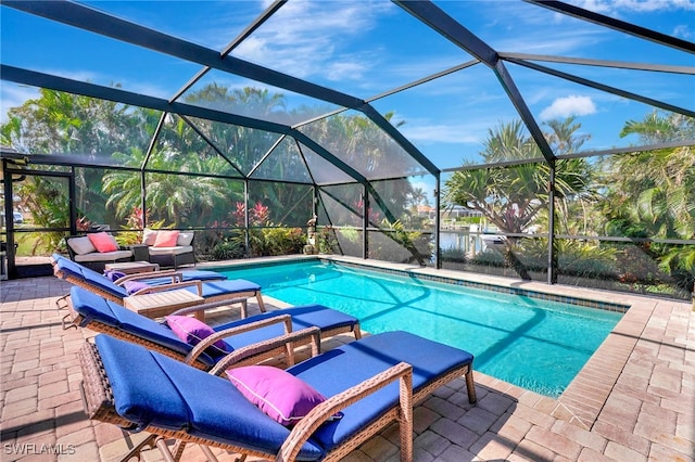 view of pool featuring glass enclosure and a patio area