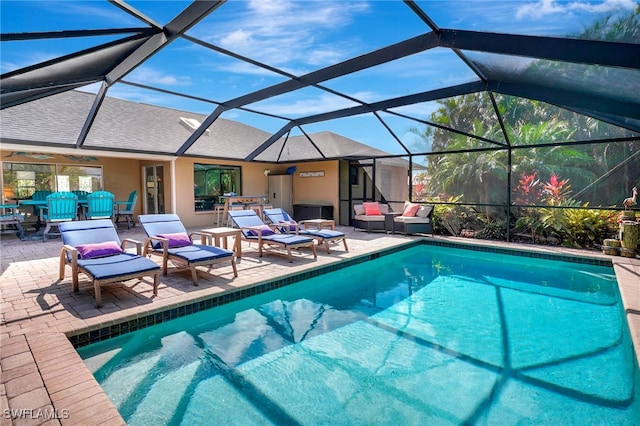 view of pool with a patio, glass enclosure, and ceiling fan