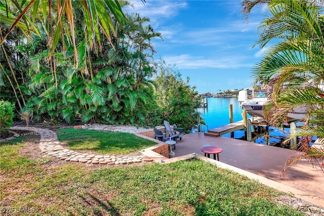 view of yard with a boat dock and a water view