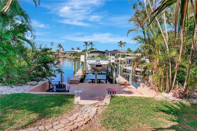 view of dock with a lawn and a water view