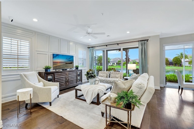 living area with baseboards, ornamental molding, dark wood finished floors, and recessed lighting