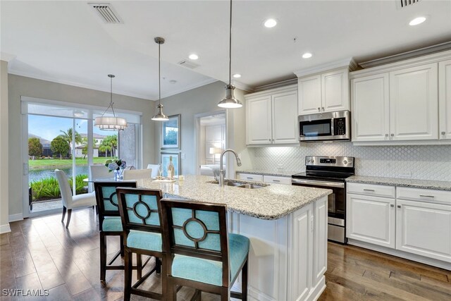 kitchen featuring a kitchen island with sink, sink, white cabinets, and stainless steel appliances