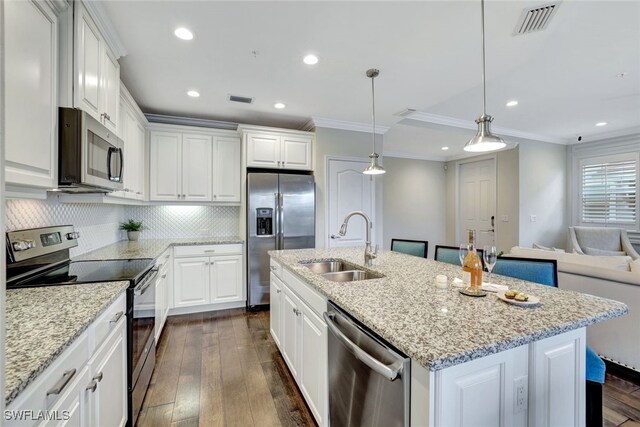 kitchen with dark wood-type flooring, a center island with sink, sink, hanging light fixtures, and stainless steel appliances