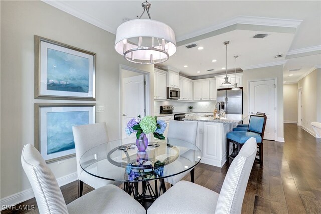 dining area featuring dark hardwood / wood-style floors, sink, and crown molding