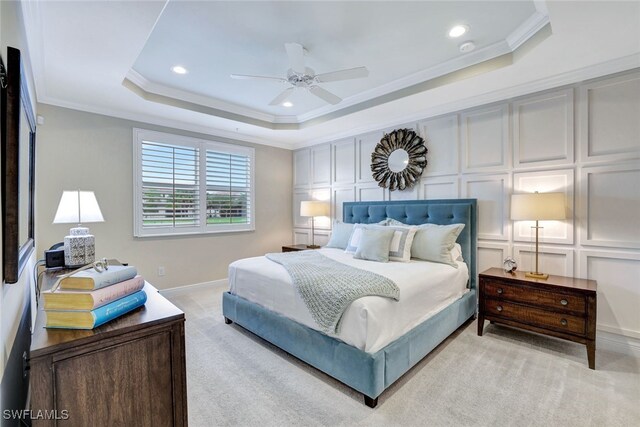 bedroom featuring light carpet, a raised ceiling, ceiling fan, and crown molding