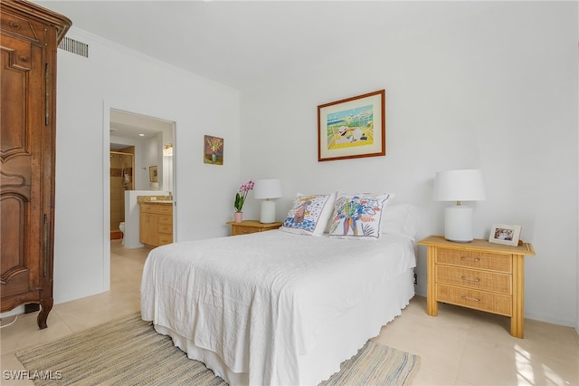 bedroom featuring ensuite bath and light tile patterned flooring