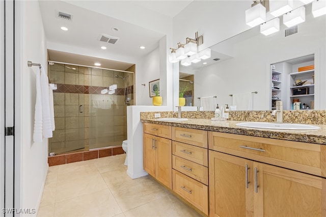 bathroom with tile patterned floors, vanity, toilet, and walk in shower