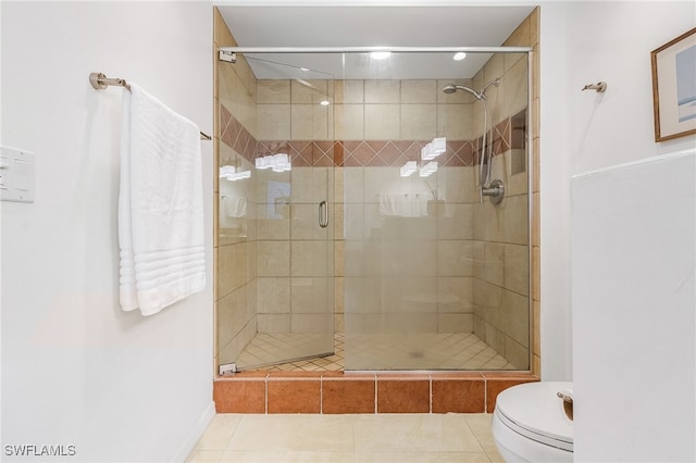 bathroom featuring tile patterned flooring, toilet, and walk in shower