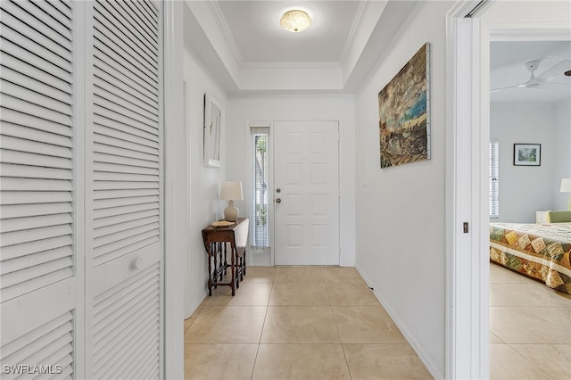 tiled foyer entrance featuring crown molding and ceiling fan