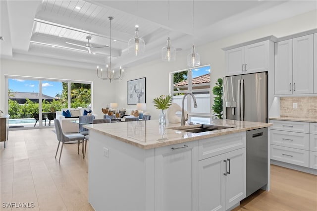 kitchen featuring white cabinets, pendant lighting, stainless steel appliances, and sink