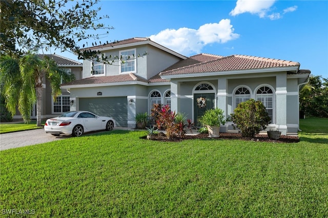 mediterranean / spanish house with a garage and a front lawn