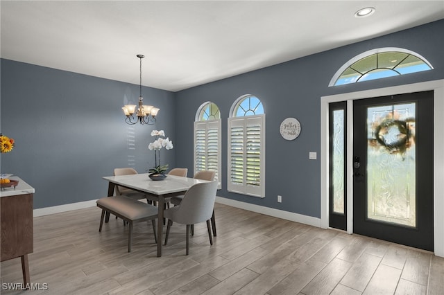 dining space with a chandelier and light hardwood / wood-style flooring