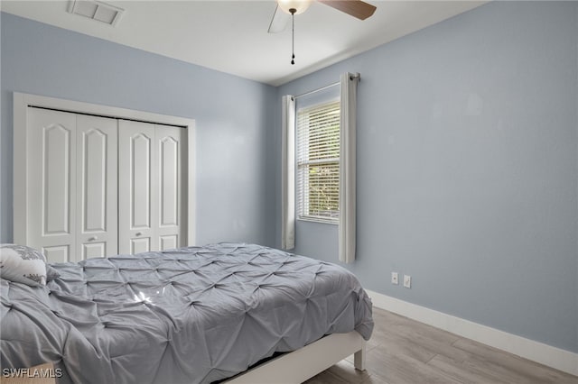 bedroom featuring light hardwood / wood-style flooring, a closet, and ceiling fan