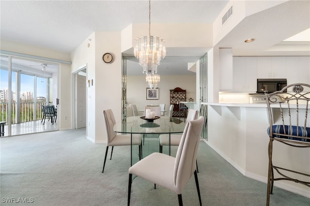 carpeted dining area featuring an inviting chandelier