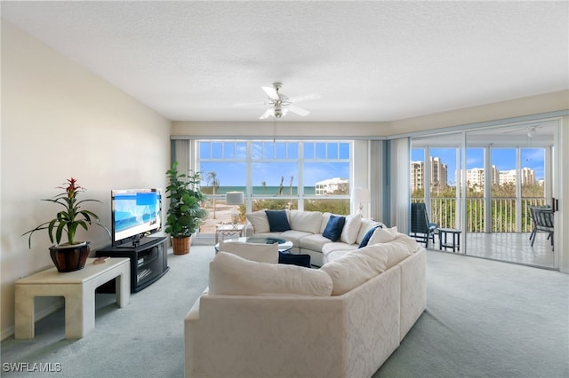 living room with a textured ceiling, ceiling fan, and light carpet