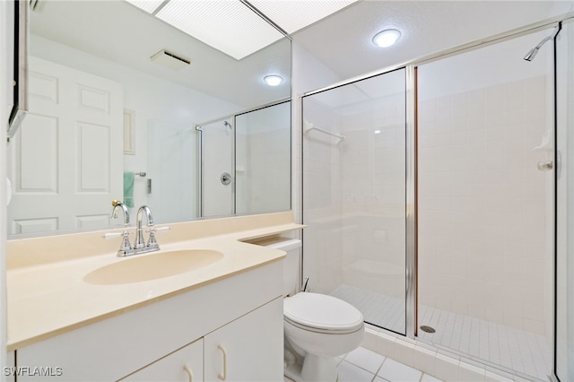 bathroom featuring tile patterned floors, vanity, toilet, and a shower with shower door