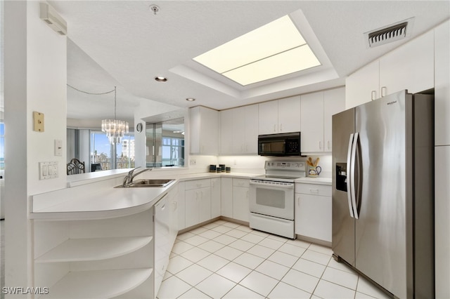 kitchen featuring white appliances, sink, white cabinetry, kitchen peninsula, and a chandelier