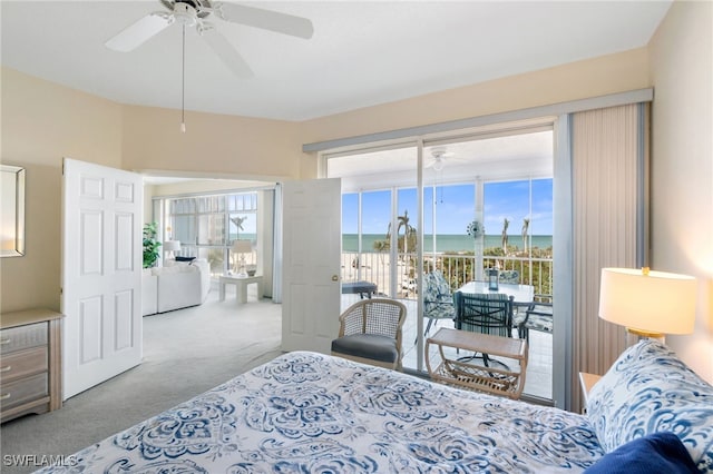 carpeted bedroom with access to exterior, a water view, and ceiling fan